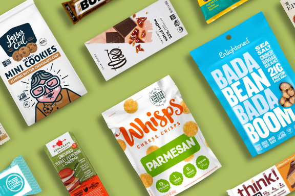 An assortment of healthy bars and snacks on a green background