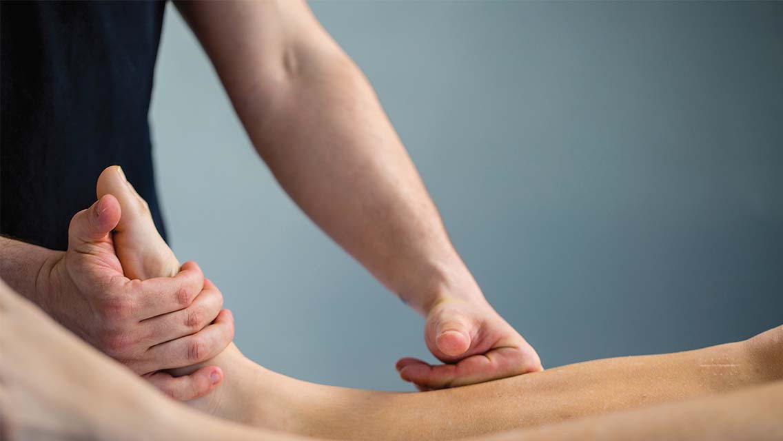 A physical therapist massaging the leg of a client 