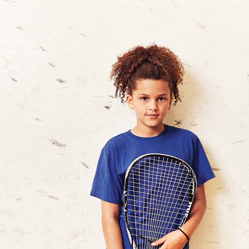 Image of a curly-haired kid holding a racquetball racquet