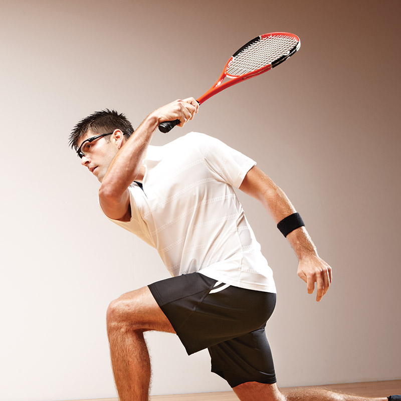 An atheltic man wearing squash gear and playing